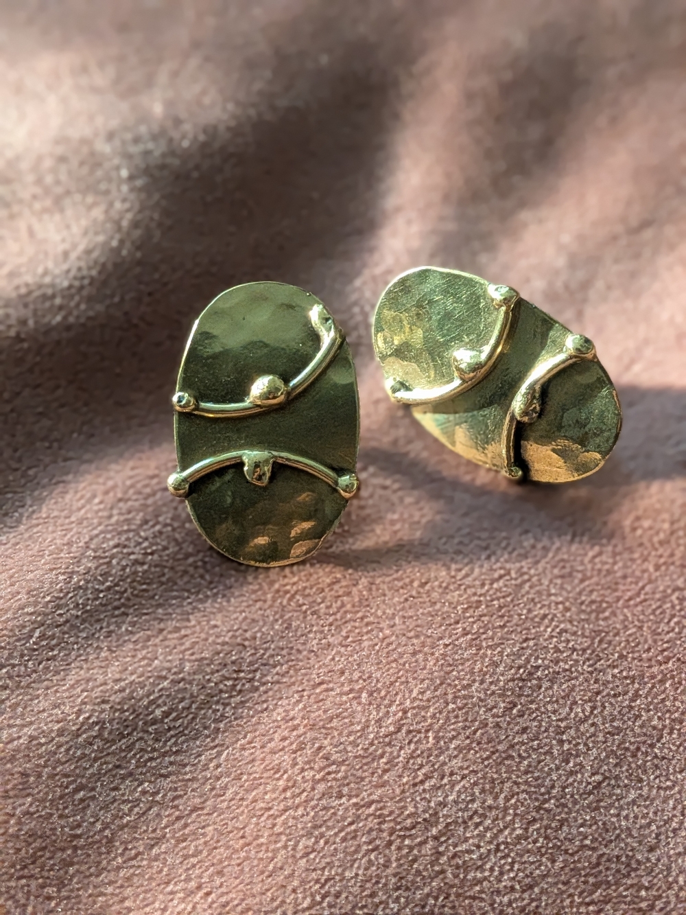 hammered, modernist brass earrings feature distinct curved accents